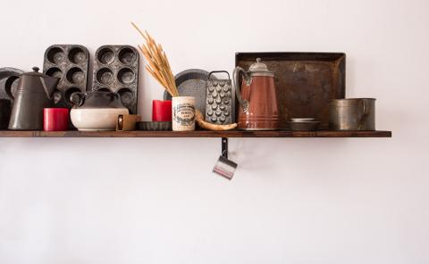 Estante rústico con utensilios de cocina vintage y artículos decorativos en tonos cálidos